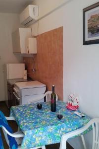 a small kitchen with a table with a bottle of wine at Apartments by the sea Drvenik Donja vala, Makarska - 11553 in Drvenik