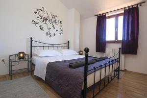 a bedroom with a bed with a black metal bed frame at Apartments with a parking space Vodnjan, Fazana - 11556 in Vodnjan