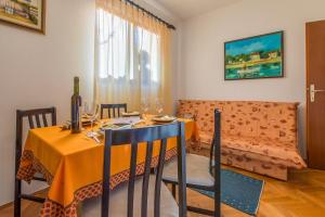 uma sala de jantar com uma mesa e um sofá em Apartments with a parking space Klenovica, Novi Vinodolski - 11559 em Klenovica
