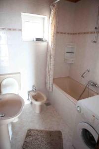 łazienka z umywalką, wanną i toaletą w obiekcie Apartments by the sea Suhi Potok, Omis - 11574 w mieście Jesenice