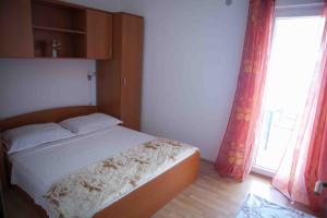 sypialnia z łóżkiem i dużym oknem w obiekcie Apartments by the sea Suhi Potok, Omis - 11574 w mieście Jesenice