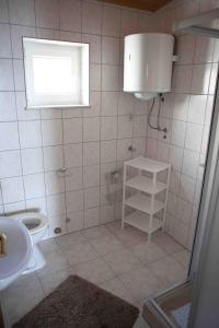 łazienka z umywalką, toaletą i oknem w obiekcie Apartments by the sea Suhi Potok, Omis - 11574 w mieście Jesenice