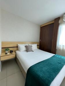 ein Hotelzimmer mit einem großen weißen Bett und einem Fenster in der Unterkunft Flat PRAIA de Camburi in Vitória