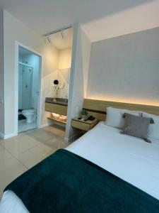 um quarto com uma cama grande e uma casa de banho em Flat PRAIA de Camburi em Vitória