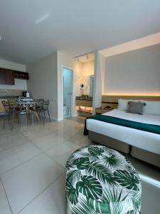 um quarto com uma cama e um repousa-pés num quarto em Flat PRAIA de Camburi em Vitória