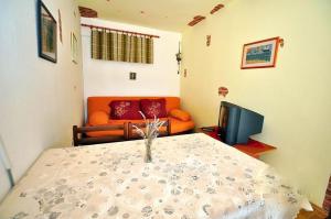 a living room with an orange couch and a television at Apartments by the sea Slatine, Ciovo - 11565 in Slatine