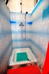 a blue tiled bathroom with a tub with a shower at Apartments by the sea Slatine, Ciovo - 11565 in Slatine