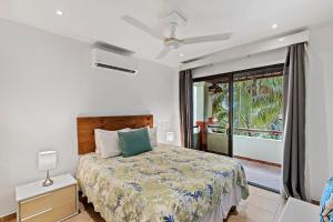 a bedroom with a bed and a large window at Colorful, Classy, Modern Split-Level Near Beach with Pool in Coco