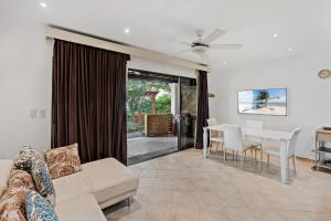 a living room with a couch and a table at Colorful, Classy, Modern Split-Level Near Beach with Pool in Coco