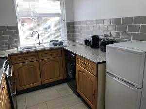 a kitchen with a sink and a white refrigerator at The Bungalow, Lingdale in Lingdale +7 photos