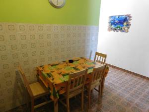 a dining room table with chairs and a clock on the wall at Apartments by the sea Drace, Peljesac - 11502 in Janjina
