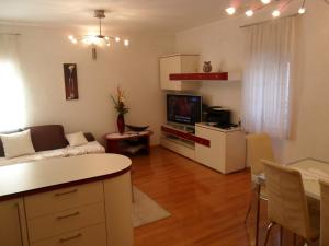a living room with a couch and a tv and a table at Apartments by the sea Senj - 11606 in Senj