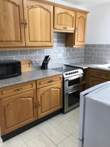 a kitchen with wooden cabinets and a stove top oven at The Bungalow, Lingdale in Lingdale