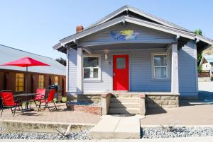 シェランにあるDeep Water Innの赤いドアとテーブルと椅子が備わる青い家