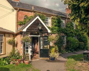 an old brick house with an open door at The Compasses Inn in Fordingbridge