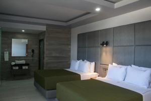 a hotel room with two beds and a bathroom at Hotel Grand One Plaza in Tijuana