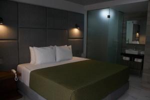 a bedroom with a large bed and a bathroom at Hotel Grand One Plaza in Tijuana