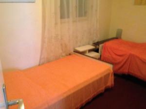 two beds in a room with orange sheets at Seaside holiday house Prigradica, Korcula - 11484 in Blato
