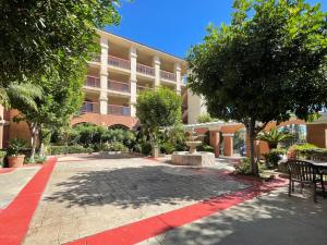 a courtyard of a building with a red sidewalk at Park Suites Hotel in South El Monte