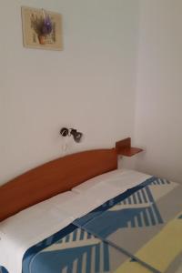 a bed with a wooden headboard in a bedroom at Apartment Sveta Nedilja 11433c in Sveta Nedelja