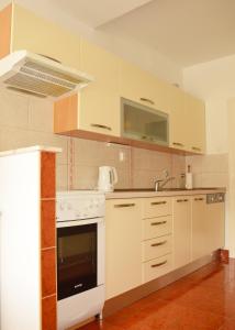 kuchnia z białymi szafkami, zlewem i kuchenką w obiekcie Apartments with WiFi Split - 11580 w Splicie