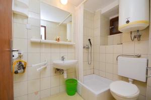 y baño con aseo, lavabo y ducha. en Apartment Brela 11552a, en Brela