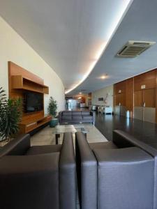 a living room with couches and a tv in a building at Flat PRAIA de Camburi in Vitória