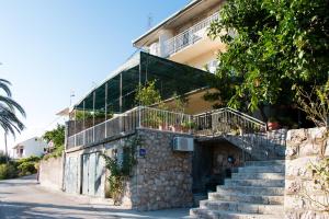 a building with stairs and a balcony on it at Apartments with a parking space Trpanj, Peljesac - 11545 in Trpanj