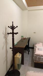 Habitación con mesa de madera y cruz de madera. en Dongyin Homestay連江縣民宿054號, en Dongyin/