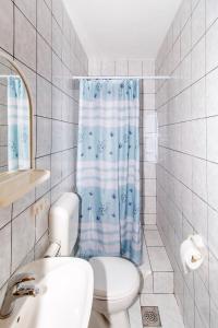 a bathroom with a toilet and a blue shower curtain at Apartments with a parking space Trpanj, Peljesac - 11545 in Trpanj