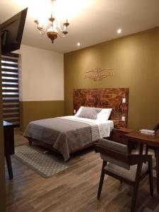 a bedroom with a bed and a desk and a television at Casa Hidalgo in Ciudad Hidalgo