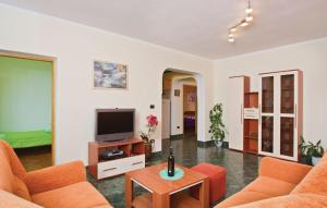 a living room with orange chairs and a television at Apartments with a parking space Fazana - 13761 in Marana