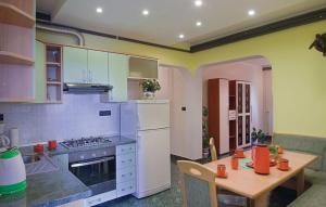 a kitchen with a table and a white refrigerator at Apartments with a parking space Fazana - 13761 in Marana