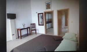 Un dormitorio con una cama, una mesa y una silla. en Apartments with a parking space Orebic, Peljesac - 13763, en Orebić