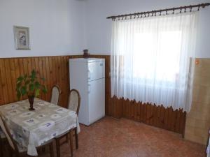 eine Küche mit einem Tisch, einem Kühlschrank und einem Fenster in der Unterkunft Apartments by the sea Ugljan - 13764 in Ugljan