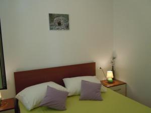um quarto com uma cama verde e 2 almofadas em Apartment Sveta Nedilja 13753d em Jelsa