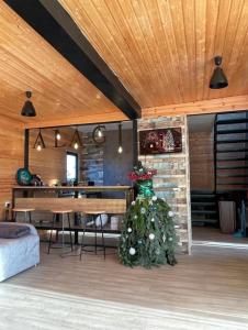 a living room with a christmas tree in the middle of a room at Alagi Cottage at Bazaleti lake in Grigolaantkari