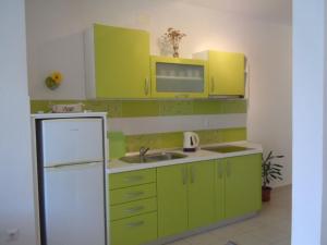 una cucina con mobili verdi e un frigorifero bianco di Apartments by the sea Sveta Nedilja, Hvar - 13753 a Jelsa (Gelsa)