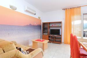 uma sala de estar com vista para o oceano em Apartments by the sea Seget Vranjica, Trogir - 13771 em Trogir