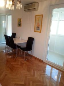 a dining room with a table and chairs on a wooden floor at Apartments by the sea Omis - 13796 in Omiš