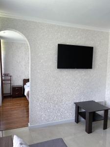 a living room with a flat screen tv on a wall at Готельно-ресторанний комплекс «Тополя» in Zwiahl