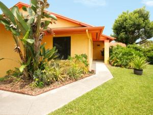 una casa amarilla con una palmera en el patio en 2 Bed 5325, en Kissimmee