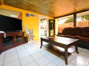 a living room with a couch and a tv at 2 Bed 5325 in Kissimmee