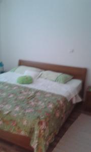 a bedroom with a bed with a wooden headboard at Apartment Zivogosce - Porat 13853c in Igrane +10 photos