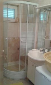 y baño con ducha y lavamanos. en Apartments by the sea Zivogosce - Porat, Makarska - 13853, en Igrane