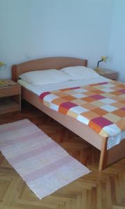 Una cama con una manta a cuadros en un dormitorio en Apartments by the sea Zivogosce - Porat, Makarska - 13853, en Igrane
