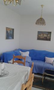 sala de estar con sofá azul y mesa en Apartments by the sea Zivogosce - Porat, Makarska - 13853, en Igrane