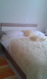 Una cama con sábanas blancas y almohadas. en Apartments by the sea Zivogosce - Porat, Makarska - 13853, en Igrane