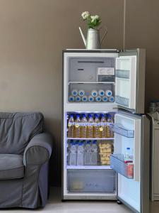 um frigorífico aberto com bebidas junto a um sofá em 春旅店民宿 Spring Hall B&B em Longtian