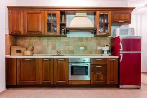 a kitchen with wooden cabinets and a red refrigerator at Family friendly house with a parking space Tribalj, Crikvenica - 13877 in Tribalj